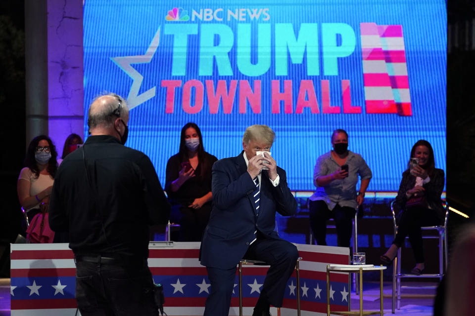 President Donald Trump wipes his face during a break in an NBC News Town Hall, at Perez Art Museum Miami, Thursday, Oct. 15, 2020, in Miami. (AP Photo/Evan Vucci)