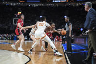 North Carolina State guard Aziaha James (10) tries to get around Texas forward Khadija Faye (20) during the first half of an Elite Eight college basketball game in the women's NCAA Tournament, Sunday, March 31, 2024, in Portland, Ore. Texas coach Vic Schaefer is at right. (AP Photo/Steve Dykes)