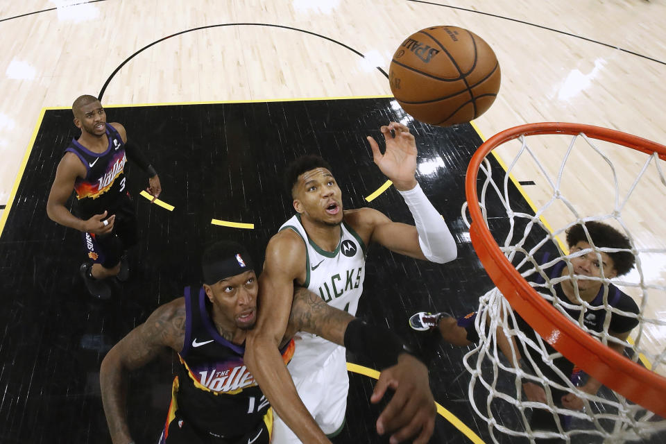 Milwaukee Bucks' Giannis Antetokounmpo (34) shoots over Phoenix Suns' Torrey Craig (12) during the second half of Game 1 of basketball's NBA Finals, Tuesday, July 6, 2021, in Phoenix. (Christian Petersen/Pool Photo via AP)