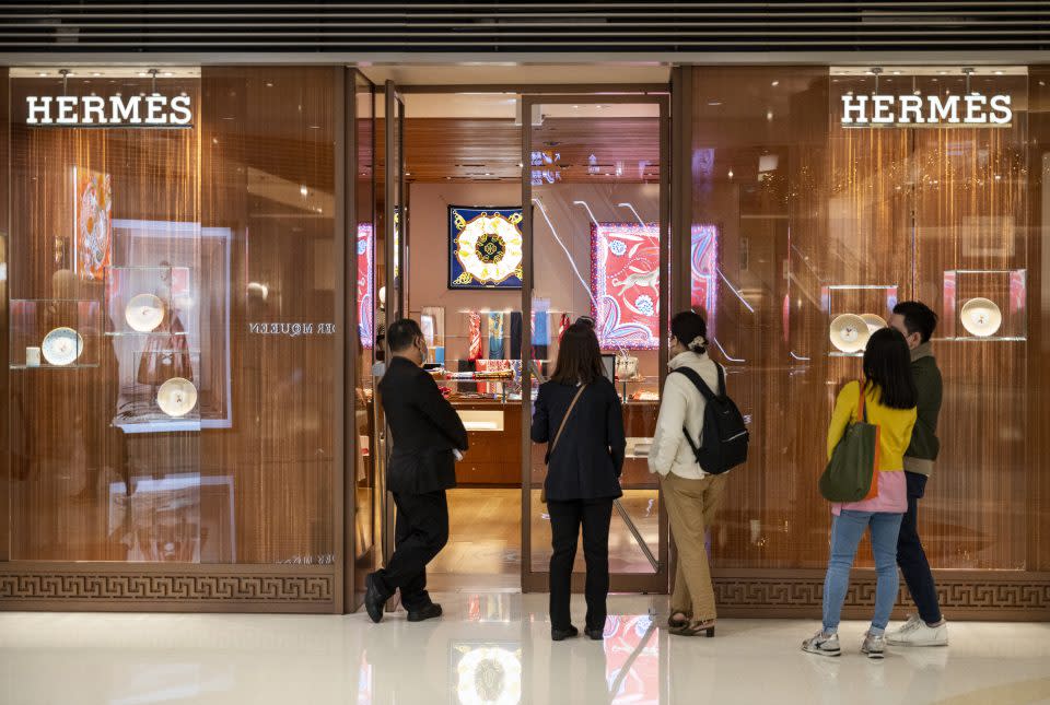 HONG KONG, CHINA - 2022/01/10: Shoppers queue to enter the French high fashion luxury clothing manufacturer Hermes store in Hong Kong. (Photo by Budrul Chukrut/SOPA Images/LightRocket via Getty Images)