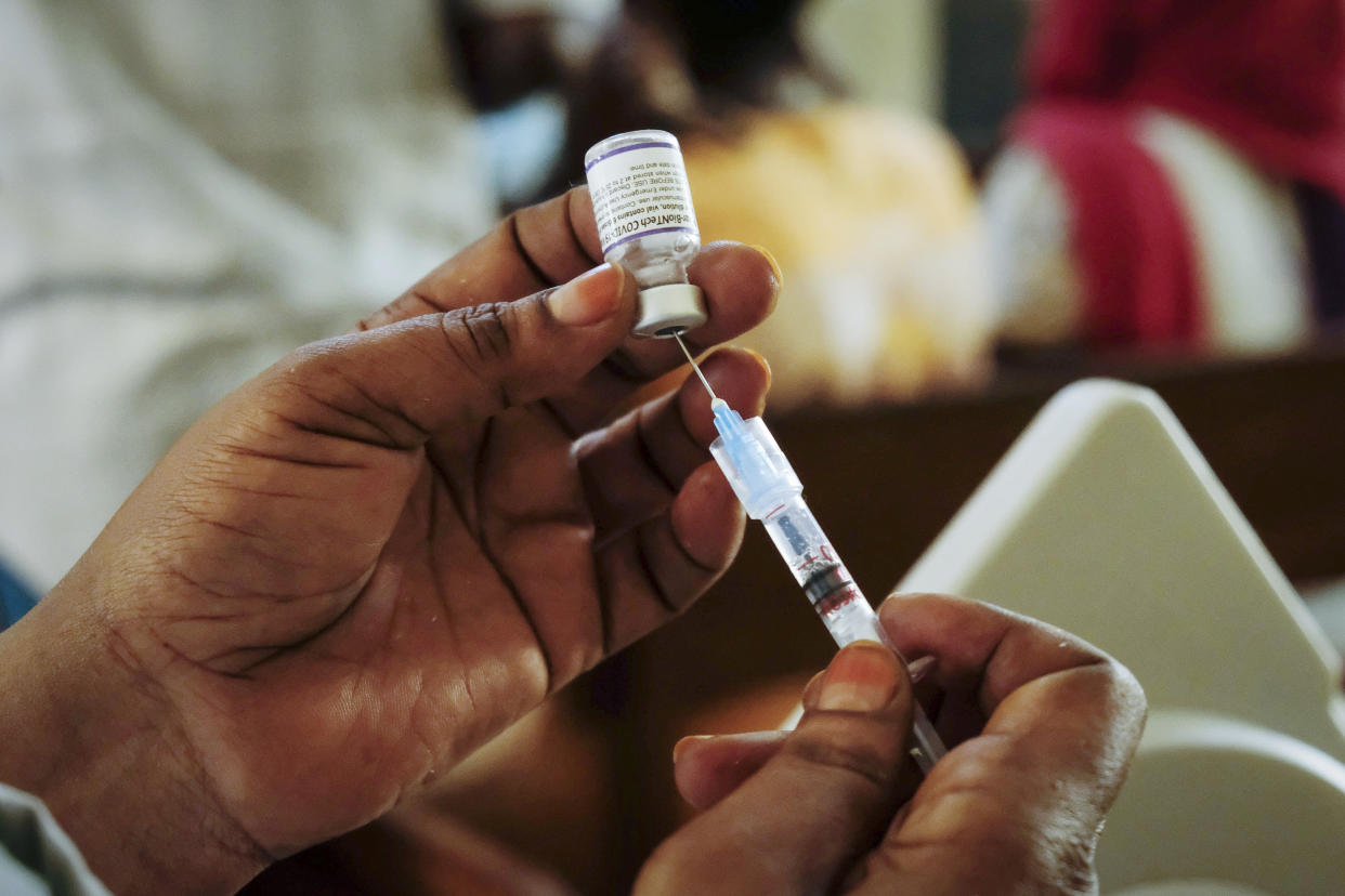 FILE - A nurse prepares a Pfizer coronavirus vaccination at the Kiswa Health Centre III in the Bugolobi neighborhood of Kampala, Uganda Tuesday, Feb. 8, 2022. In the latest Senate package targeted at stopping the coronavirus, U.S. lawmakers dropped nearly all funding for curbing the virus beyond its borders, in a move many health experts describe as dangerously short-sighted. They warn the suspension of COVID aid for poorer countries could ultimately spur the kind of unchecked transmission needed for the next worrisome variant to emerge. (AP Photo/Hajarah Nalwadda, File)