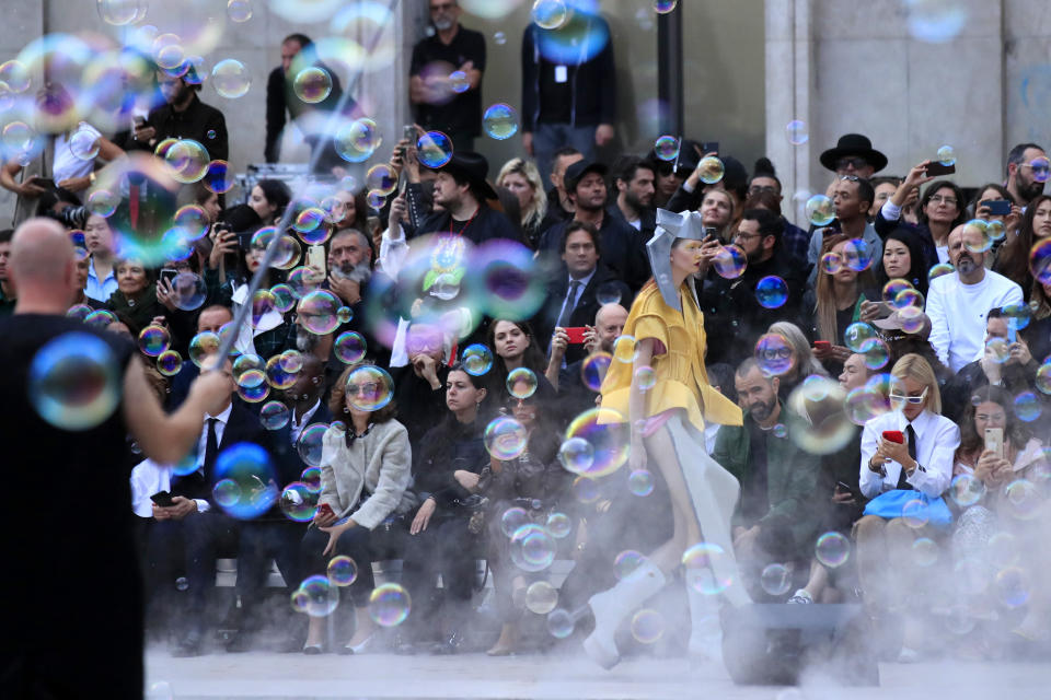 A show worker, left, produces bubbles as a model wears a creation as part of the Rick Owens Ready To Wear Spring-Summer 2020 collection, unveiled during the fashion week, in Paris, Thursday, Sept. 26, 2019. (AP Photo/Michel Euler)