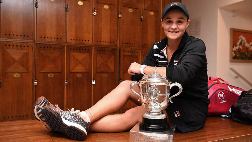 Ashleigh Barty celebrates victory with the winners trophy in the dressing room. (Photo by Corinne Dubreuil/FFT-Pool/Getty Images)