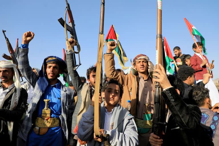 (FILES) Yemeni protesters brandish their weapons during a protest following US and British forces strikes, in the Huthi-controlled capital Sanaa on January 12, 2024 amid the ongoing battles between Israel and the militant Hamas group in Gaza. Yemen's Huthi rebels launched missiles at ships in the Red Sea on January 24, 2024, but two were intercepted and the third missed, the White House said. (Photo by MOHAMMED HUWAIS / AFP)