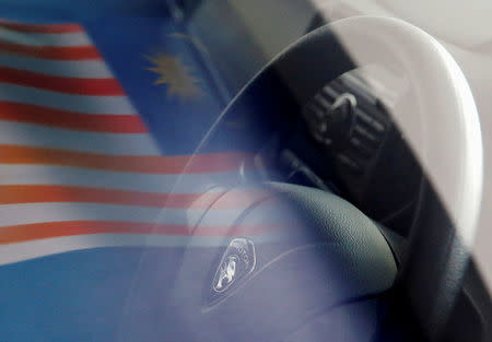 FILE PHOTO: A Malaysian flag is reflected on a car window at a Proton showroom in Puchong, Malaysia October 3, 2016. REUTERS/Edgar Su/File Photo