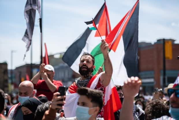 A man waves a Palestinian flag at Saturday's rally. Police say between 2,000 and 3,000 people attended.