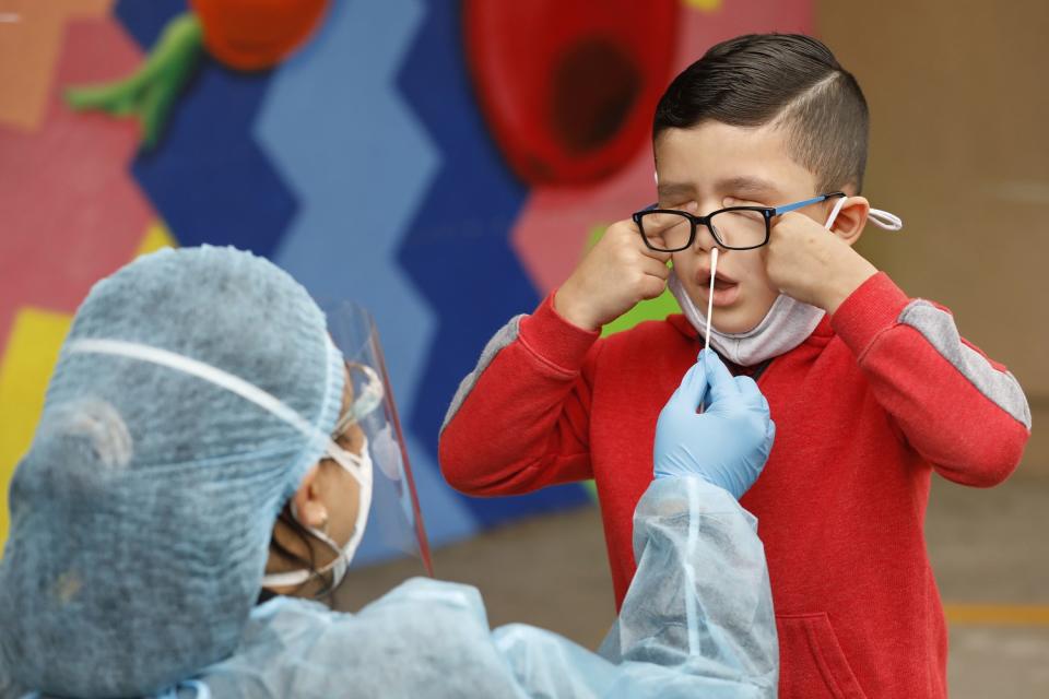 Kindergartner Matteo Rodriguez gets a COVID-19 test from EMT Claire Chou.