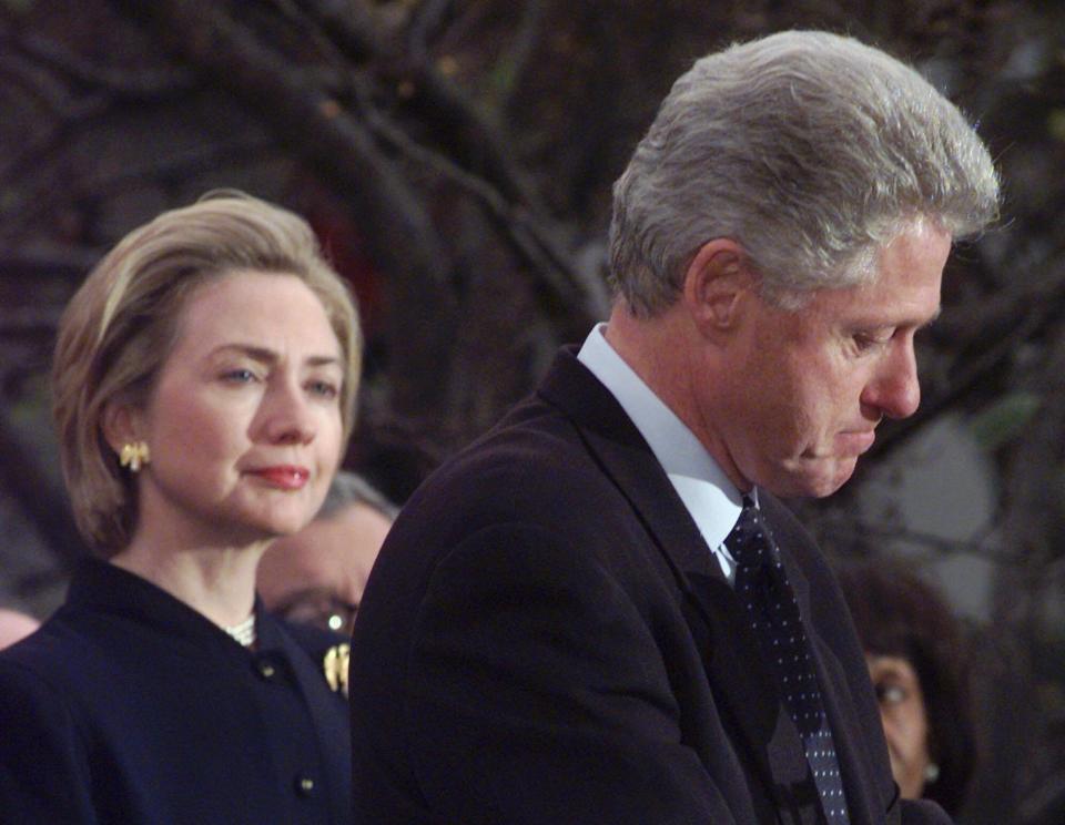 First lady Hillary Clinton looks on as President Bill Clinton makes a statement at the White House on Dec. 19, 1998, thanking Democratic House members who voted against impeachment and vowing to complete his term.