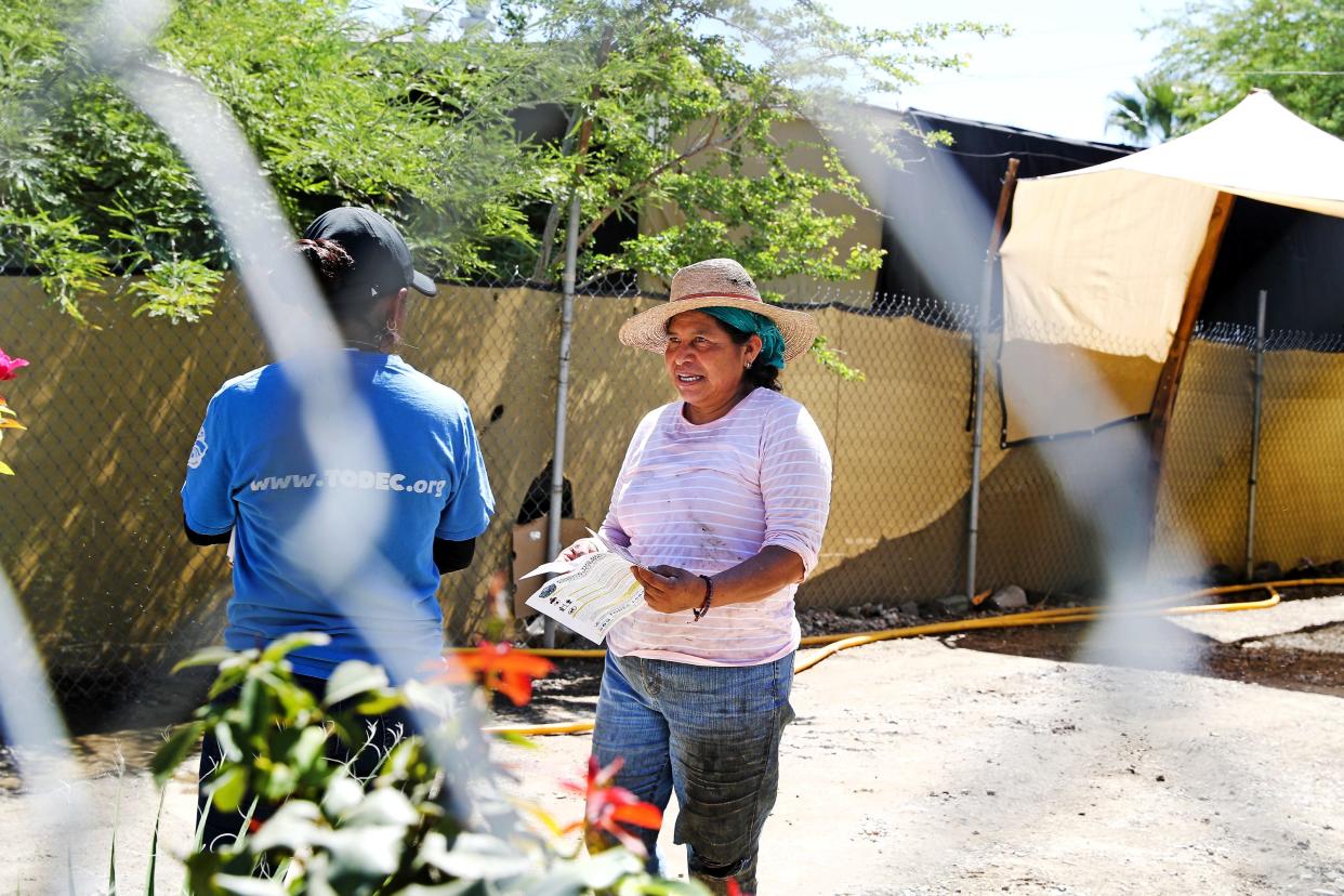 Natalia Margarito with the outreach team from TODEC speaks with resident Lucila Vasquez Morales on Wednesday at the Vargas Mobile Home Park in Thermal, one of three communities at risk after a breach at a toxic dump site.