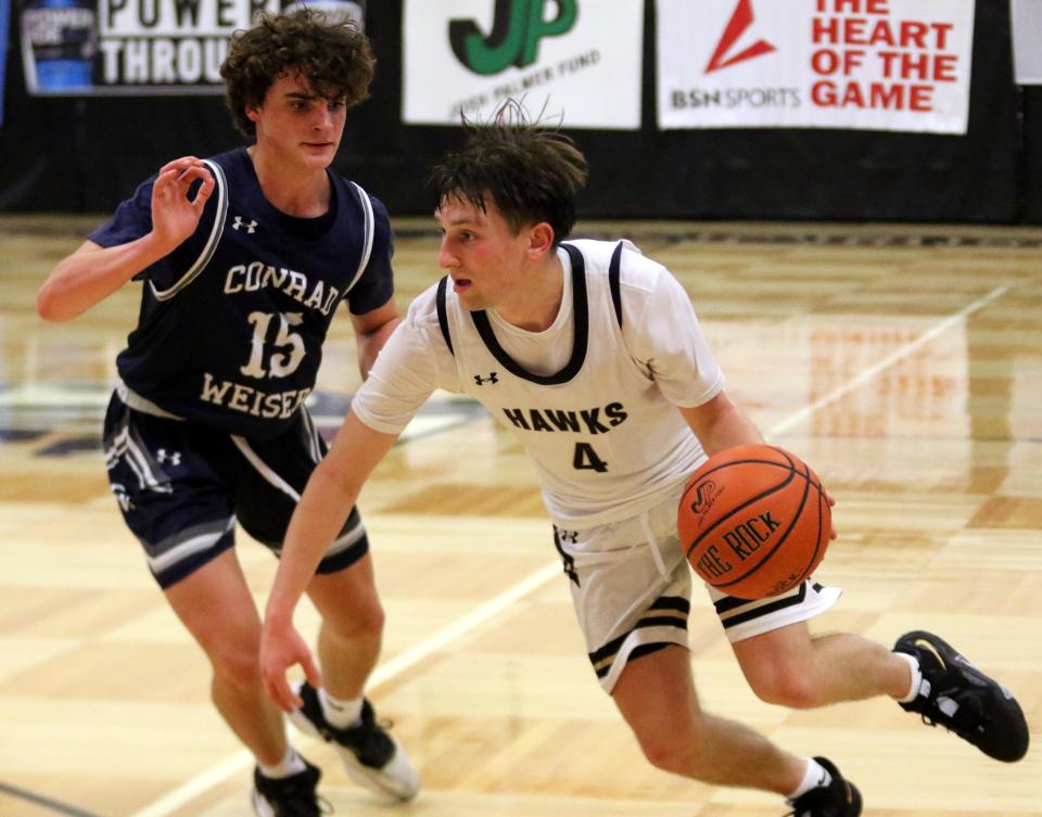 Corning's Jackson Casey is defended by Conrad Weiser's Alex Malone during the Hawks' 58-50 win in a Boys Regional Division 2 semifinal Dec. 28, 2022 at Elmira High School.