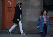 A man wearing a mask walks in the centre of Edinburgh