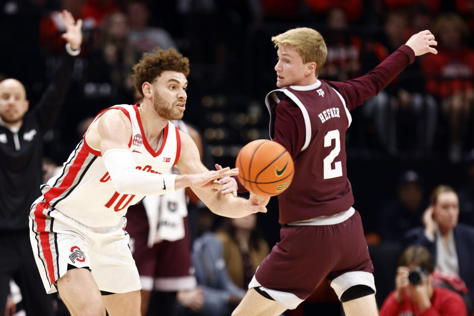 Ohio State forward Jamison Battle, left, passes the ball behind Texas A&M guard Hayden Hefner (2) during the first half of an NCAA college basketball game in Columbus, Ohio, Friday, Nov. 10, 2023. (AP Photo/Paul Vernon)