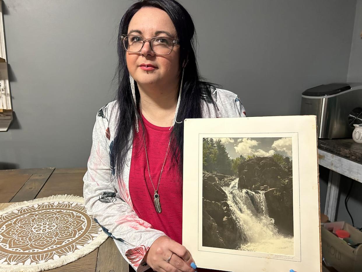 Kara Acorn holds one of the photographs by F.O. MacLeod, dated 1927, that she discovered in her home. (Stacey Janzer/CBC - image credit)