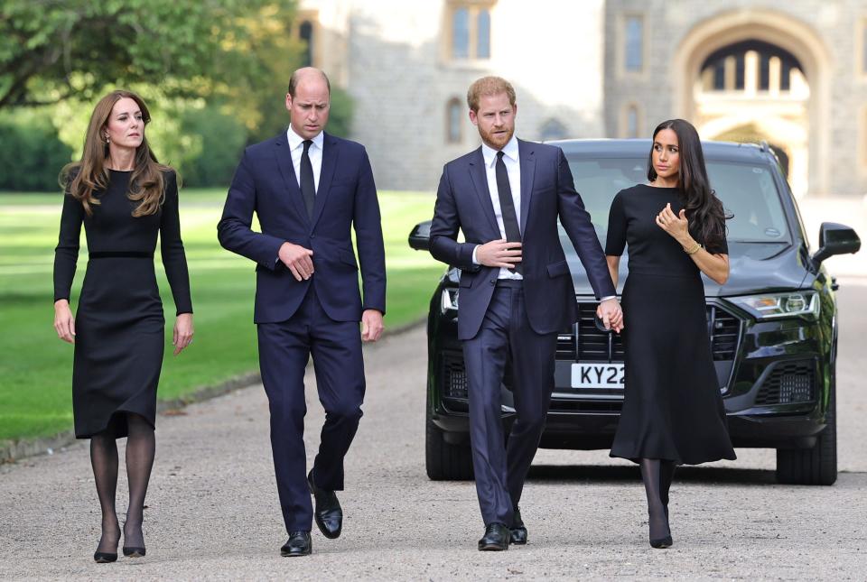 Kate, Princess of Wales (from left), Prince William, Prince Harry and Duchess Meghan walk outside Windsor Castle to greet the crowds leaving tributes to Queen Elizabeth II.