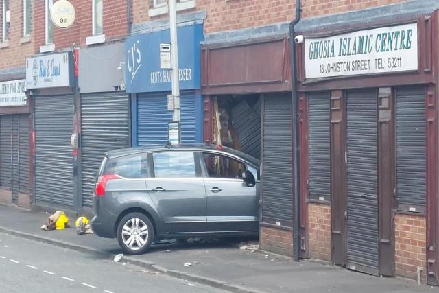 Blackburn road closed as car crashes into shop front