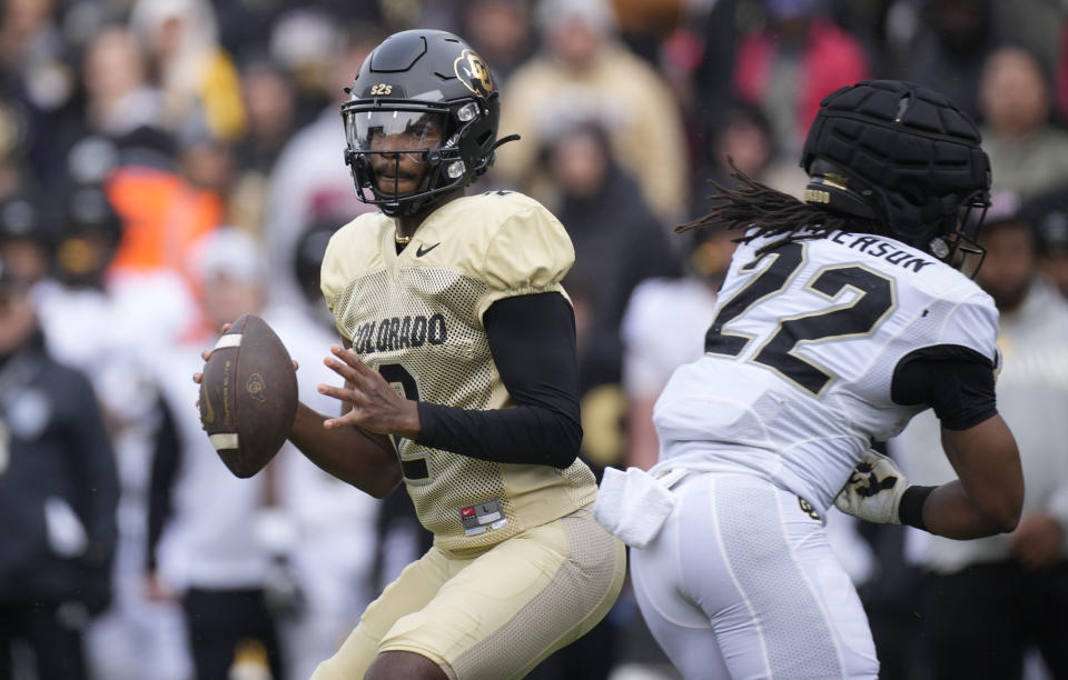 Colorado quarterback Shedeur Sanders, left, rolls out to pass the ball as running back Anthony Hankerson blocks in the first half of the team's spring practice NCAA college football game Saturday, April 22, 2023, in Boulder, Colo. (AP Photo/David Zalubowski)