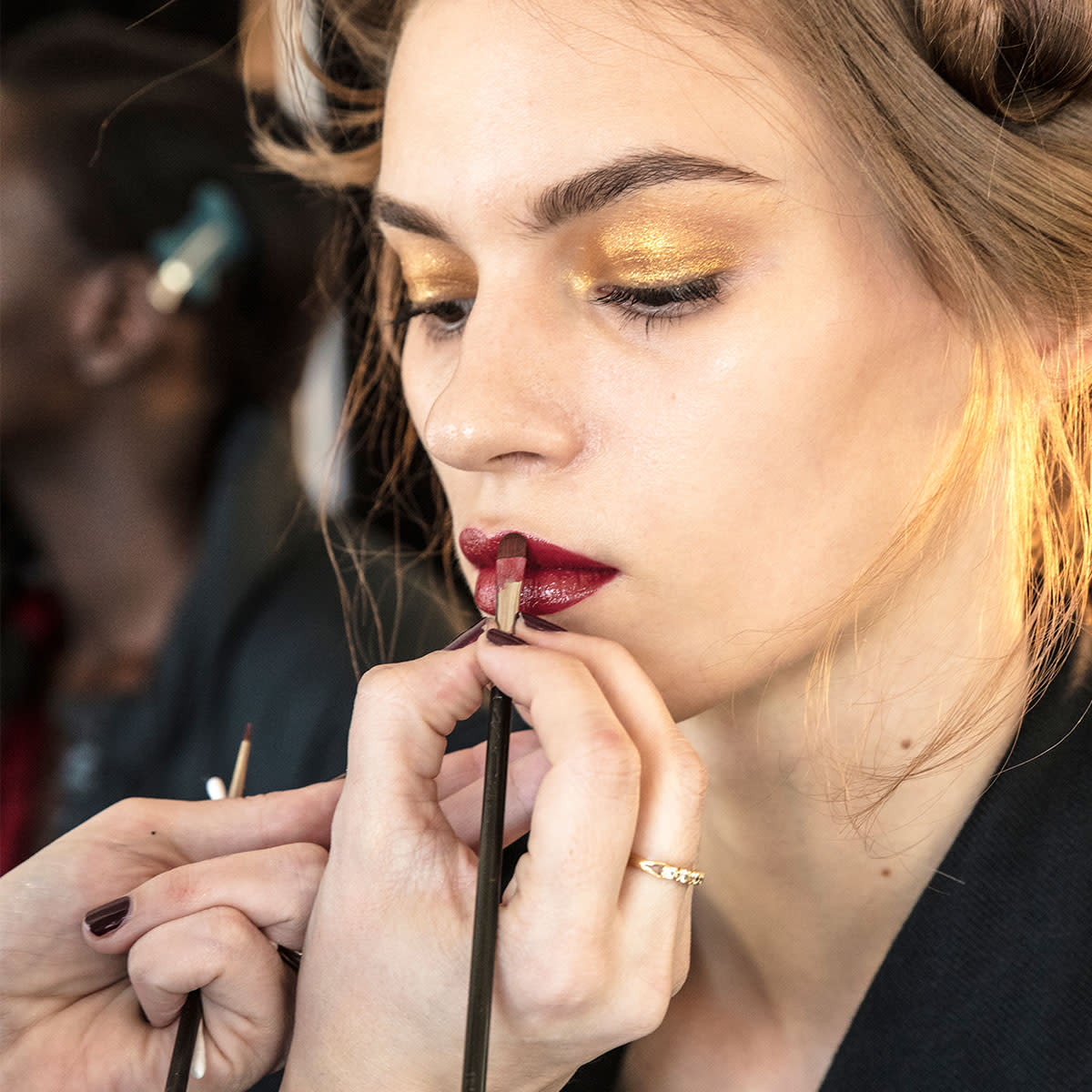 makeup-artist-applying-dark-red-lipstick