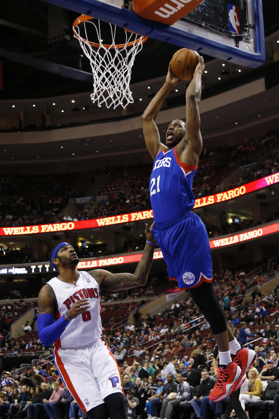 Philadelphia 76ers' Thaddeus Young, right, goes up for a dunk against Detroit Pistons' Josh Smith during the first half of an NBA basketball game on Saturday, March 29, 2014, in Philadelphia. (AP Photo/Matt Slocum)