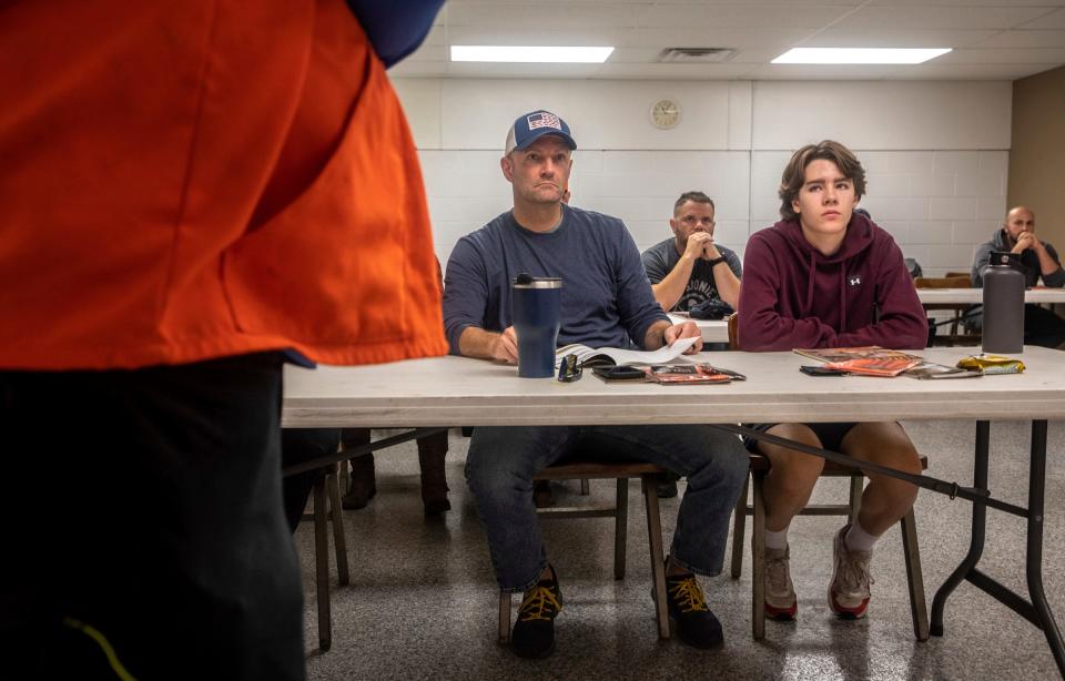 Clinton Garrett, left, sits next to his son Brandon Garrett during a Hunter Safety Field Day at the Washtenaw Sportsman's Club in Ypsilanti on Saturday, Sept. 9, 2023. Clinton and Brandon attended the hunter safety class to get their hunting license to hunt legally and safely in Michigan.