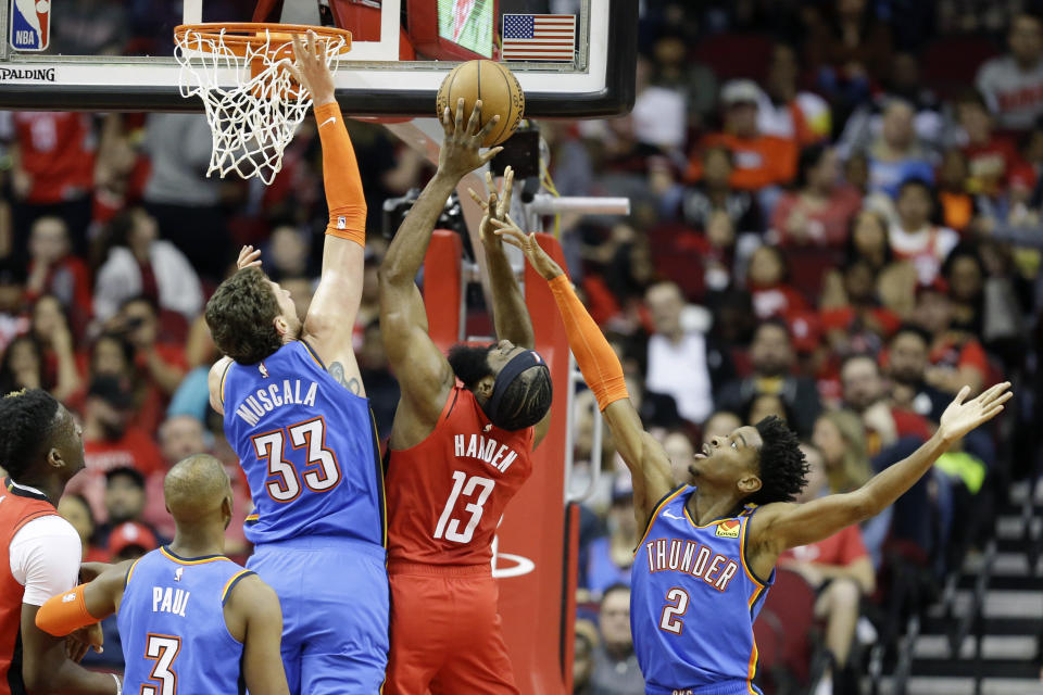 Houston Rockets guard James Harden (13) shoots as Oklahoma City Thunder forward Mike Muscala (33) and guard Shai Gilgeous-Alexander (2) defend during the first half of an NBA basketball game, Monday, Jan. 20, 2020, in Houston. (AP Photo/Eric Christian Smith)