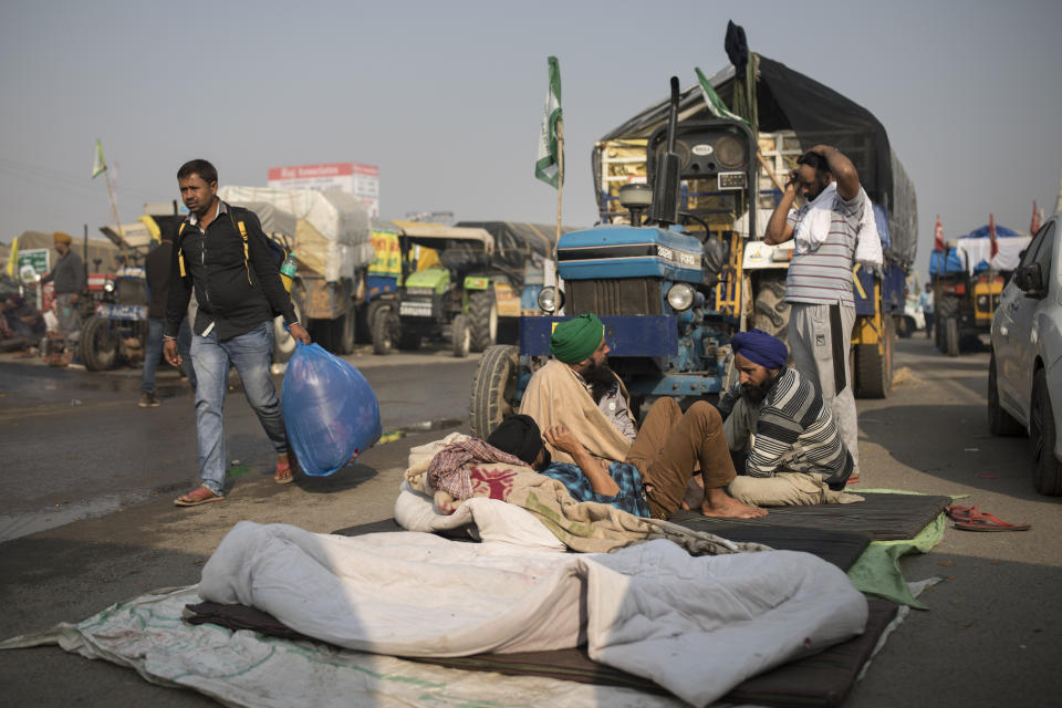 Protesting farmers sit next to their tractor as they get ready to join protests at the border between Delhi and Haryana state, Tuesday, Dec. 1, 2020. Talks between protesting farmers and the Indian government failed Tuesday after both the parties could not reach a common ground to discuss the new farming laws, protests against which have intensified after entering their sixth day. More growers joined giant demonstrations and choked roads to India's Capital by hunkering down along with their trucks and tractors. (AP Photo/Altaf Qadri)