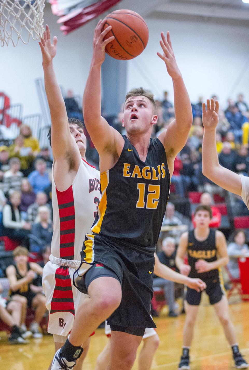 Colonel Crawford's Gavin Feichtner finishes at the basket past Buckeye Central's Brady Kerschner.