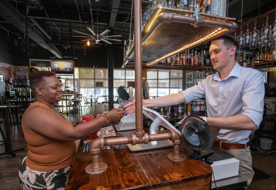 NeRissa Bates, left, places an order with bartender Chandler Mathieson at the Steam Joint at Casks & Flights in downtown Pensacola on Wednesday, April 12, 2023.
