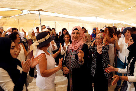 Palestinian and Israeli women celebrate inside a "peace tent" erected as part of an event organised by "Women Wage Peace" group calling for an end to the Israeli-Palestinian conflict, near the Jordan River, in the occupied West Bank October 8, 2017. REUTERS/Ronen Zvulun