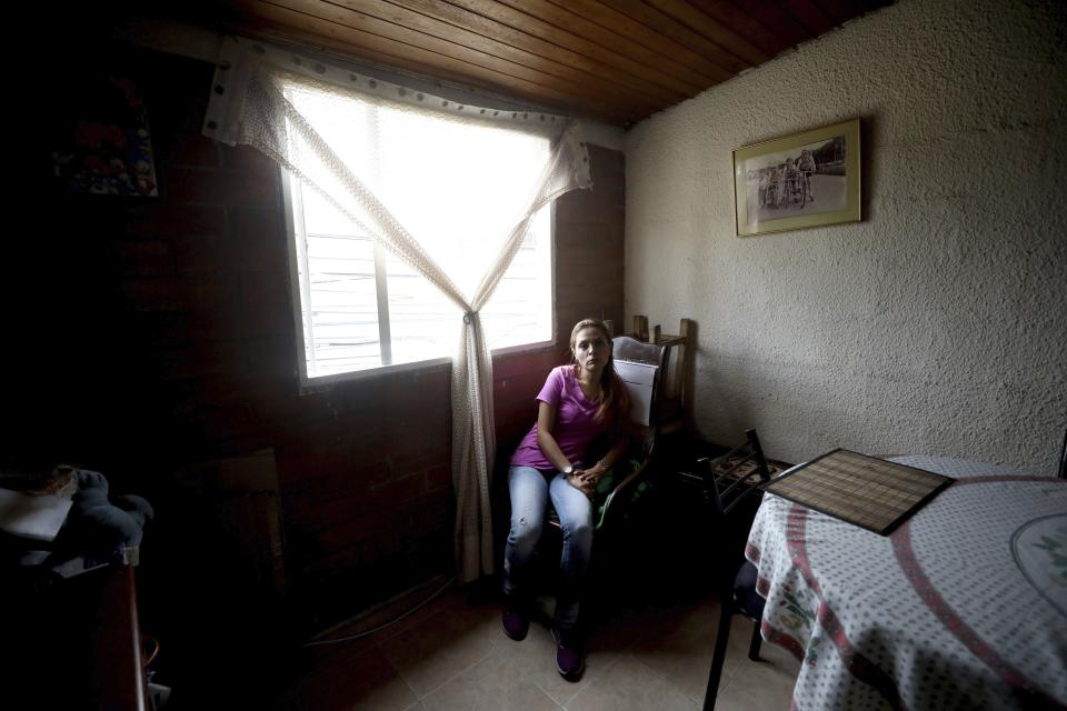 Myriam Roncancio, 35, who is living with her parents after breaking up with her husband of 10 years, sits in a chair during an interview in the Soacha borough of Bogota, Colombia, Tuesday, July 28, 2020. After she lost her job as a restaurant administrator at the start of the new coronavirus outbreak and her husband lost his as a baggage handler at Bogota’s airport, they were unable to pay their rent and their quarreling became more frequent. That’s when he left, she says. (AP Photo/Fernando Vergara)