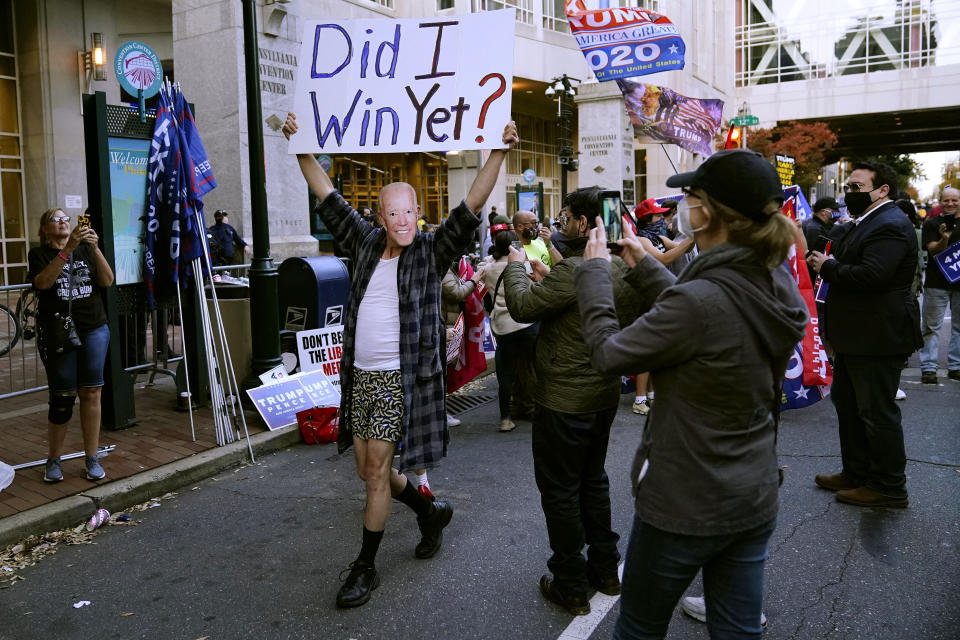 A supporter of President Donald Trump wears a mask made from a photograph of Vice President Joe Biden outside the Pennsylvania Convention Center where votes are being counted, Thursday, Nov. 5, 2020, in Philadelphia, following Tuesday's election. (AP Photo/Matt Slocum)