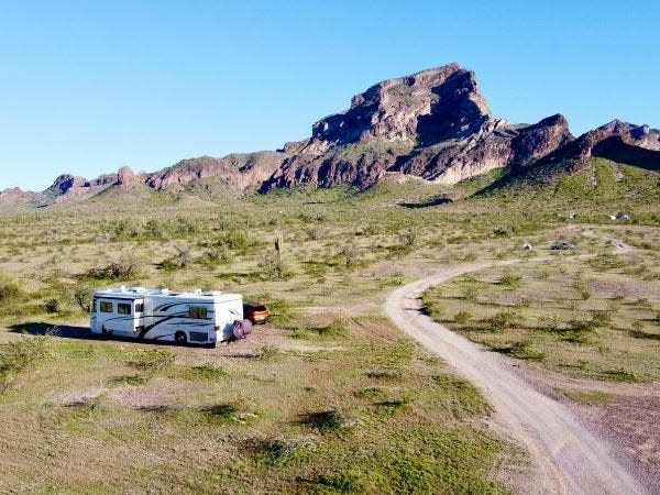 An RV in a filed and Saddle Mountain int he distance. Blue skies all around.