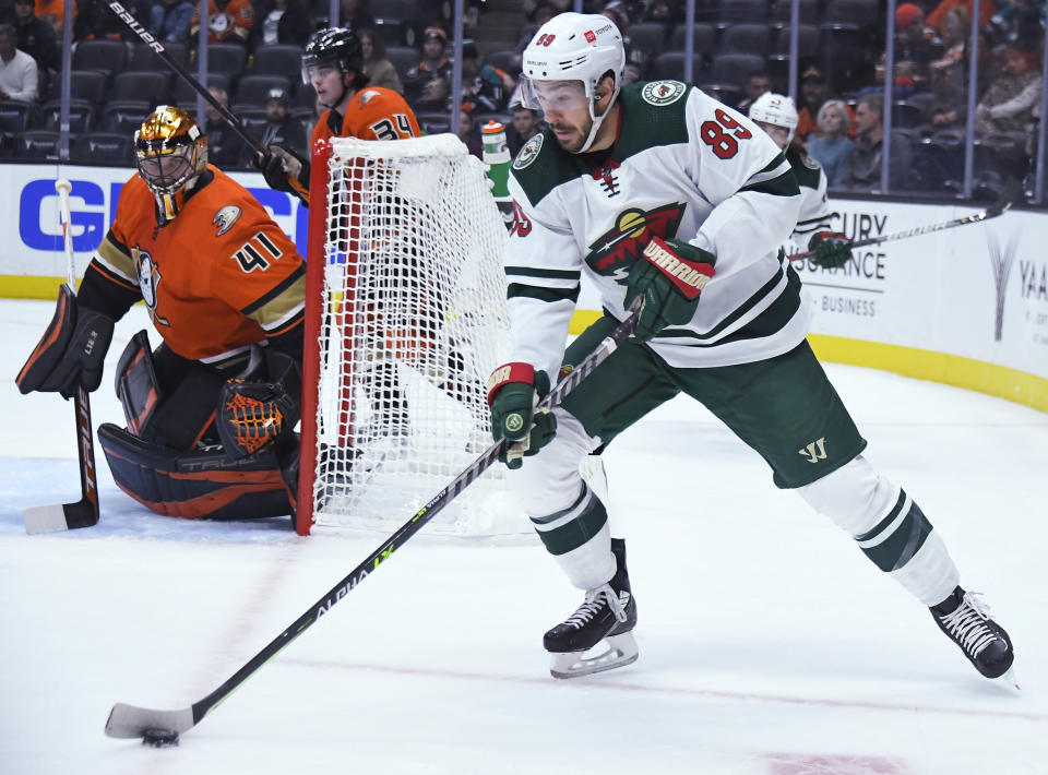 Anaheim Ducks goaltender Anthony Stolarz (41) keeps an eye on Minnesota Wild center Frederick Gaudreau (89) during the first period of an NHL hockey game Friday, Oct. 15, 2021, in Anaheim, Calif. (AP Photo/John McCoy)