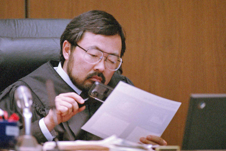 FILE – Judge Lance Ito views evidence with a magnifying glass during O.J. Simpson’s double-murder trial, Aug. 25, 1995, in Los Angeles. Simpson, the decorated football superstar and Hollywood actor who was acquitted of charges he killed his former wife and her friend but later found liable in a separate civil trial, has died. He was 76. (AP Photo/Pool/Mark J. Terrill, File)