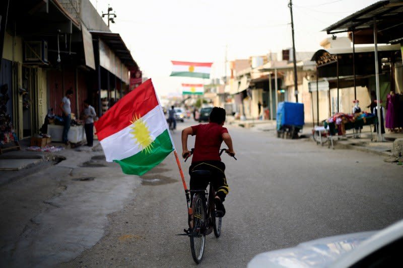 File Photo - A boy rides a bicycle with the flag of Kurdistan in Tuz Khurmato, Iraq September 24, 2017. REUTERS/Thaier Al-Sudani