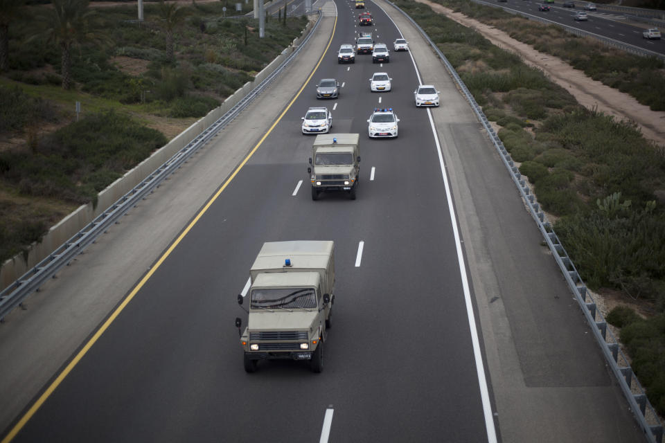 A military and police convoy escort the coffin of the late Israeli Prime Minister Ariel Sharon on route to Jerusalem from a military base near Rishon Letzion in central Israel, Sunday, Jan. 12, 2014. The body of Ariel Sharon, Israel's hard-charging former prime minister and general will be brought to Israel's parliament building in Jerusalem where it will lie in state Sunday a day after his death aged 85. (AP Photo/Ariel Schalit)