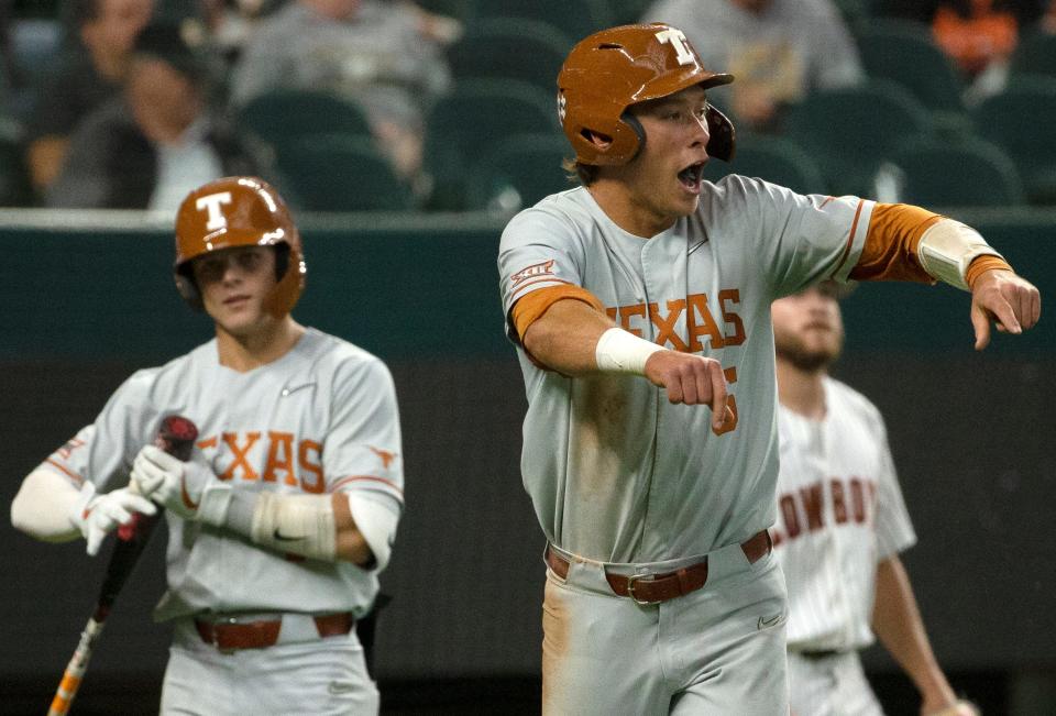 Texas' Skyler Messinger (5), right, gestures after scoring a run against Oklahoma State in the first-round Big 12 tournament game, Wednesday, May 25, 2022, at Globe Life Field in Arlington. Texas won, 4-0.