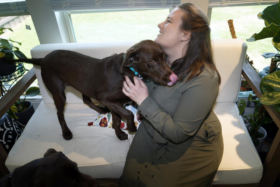 Jessica Bernardo sits with one of her three Labradors at her home in Little Elm, Texas, Thursday, May 18, 2023. (AP Photo/LM Otero)