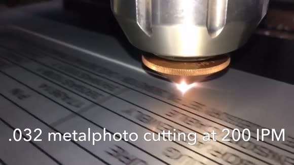 Laser cutting through metal, with caption explaining exact metrics.