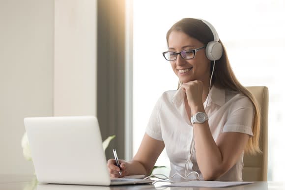 A woman video conferencing on a laptop.