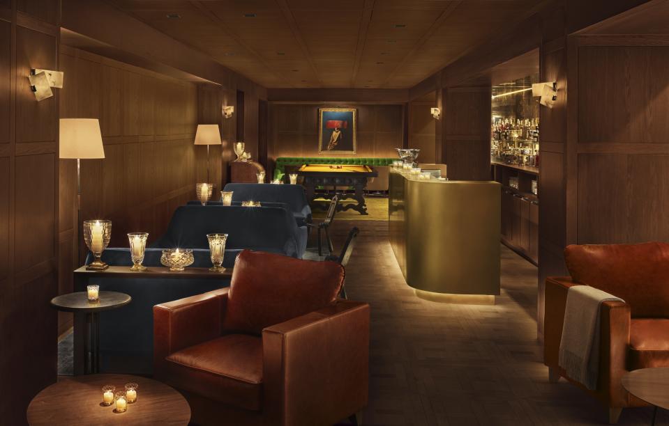 The Punch Room at the Barcelona Edition, where the golden glow that the lamps cast is meant to accentuate texture, the grain on wood paneling, and the plush of jade velvet sofas.