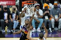 Phoenix Suns guard Cameron Payne (15) scores against Los Angeles Clippers forwards Nicolas Batum, right, and Marcus Morris Sr., back left, during the first half of Game 1 of the NBA basketball Western Conference finals Sunday, June 20, 2021, in Phoenix. (AP Photo/Ross D. Franklin)