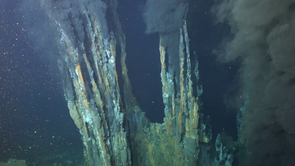 Black smokers emit clouds of mineral-filled fluid at the Beebe Vent Field at the Mid-Cayman Rise, the location of the deepest and hottest known hydrothermal vents in the world. As the minerals cool, they create towering chimneys on the seafloor. This image was captured during the science verification expedition this summer with Alvin.