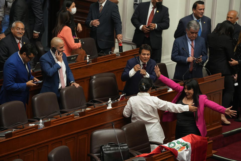 Lawmakers celebrate after verbally voting to remove President Pedro Castillo from office in Lima, Peru, Wednesday, Dec. 7, 2022. Peru's Congress voted to remove Castillo from office Wednesday and replace him with the vice president, shortly after Castillo tried to dissolve the legislature ahead of a scheduled vote to remove him.(AP Photo/Guadalupe Pardo)