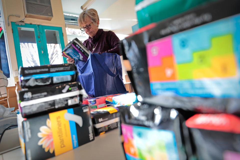 Volunteer, Carol Kerrissey divides the items the Women's Fund collected during their hygiene drive in New Bedford, These bags will be delivered to both the Grace House and Parenting Teens organizations in New Bedford.