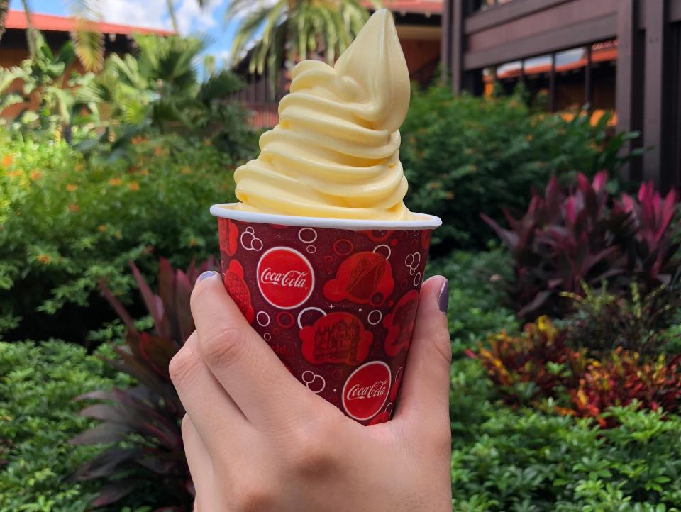 hand holding cup of dole whip at disney polynesian resort