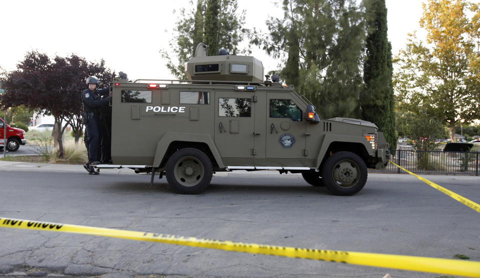 Sacramento Police officers respond to a home that authorities have surrounded where a gunman has taken refuge after shooting a Sacramento police officer, Wednesday, June 19, 2019, in Sacramento, Calif. (AP Photo/Rich Pedroncelli)