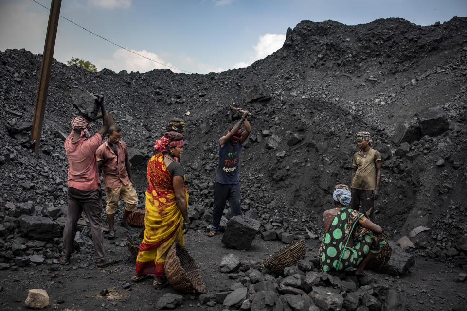 FILE- Laborers load coal onto trucks for transportation near Dhanbad, an eastern Indian city in Jharkhand state, Friday, Sept. 24, 2021. India has yet to submit its targets for cutting greenhouse emissions to the U.N climate agency. Four months have passed since Indian Prime Minister Narendra Modi announced its 'net-zero' target and short-term goals for increasing clean energy. (AP Photo/Altaf Qadri,file)