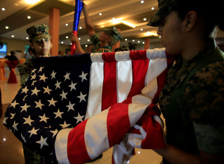 Members of the U.S. Marine corps roll the American flag after the Philippines-US amphibious landing exercise (PHIBLEX) closing ceremony inside the Philippine Marines headquarters in Taguig city, metro Manila, Philippines October 11, 2016. REUTERS/Romeo Ranoco/File Photo