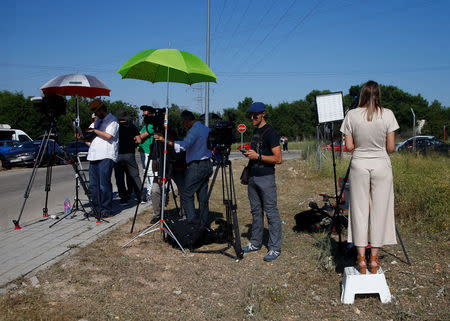 Journalists wait outside the prison where two of the five men cleared of gang rape of a teenager and convicted of a lesser crime of sexual abuse are due to leave jail after being granted provisional release in Alcala de Henares, near Madrid, Spain, June 22, 2018. REUTERS/Javier Barbancho