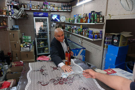 A man sells liquor in his shop, after it was banned during the Islamic State militants' seizure of the city, in Mosul, Iraq April 18, 2019. REUTERS/Abdullah Rashid